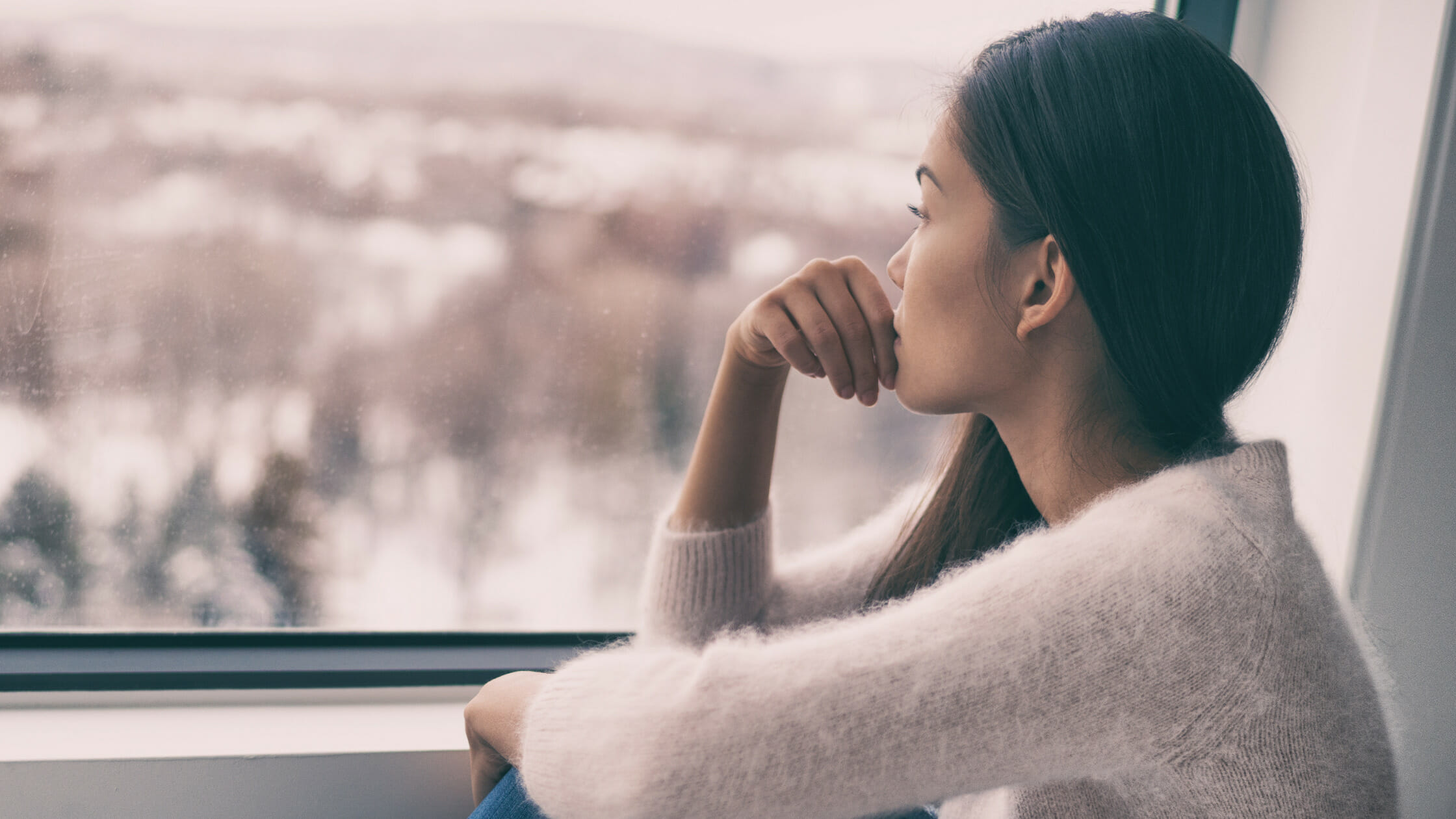 Woman looking out the window intensely and pondering